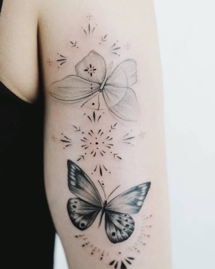 Ornamental butterfly couple tattoo done on the tricep.