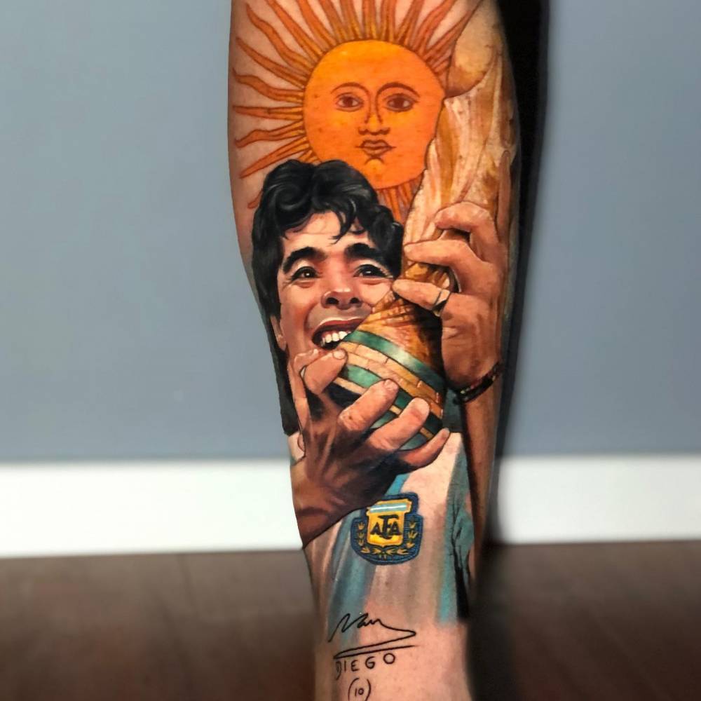 Realistic Maradona portrait tattoo located on the shin.