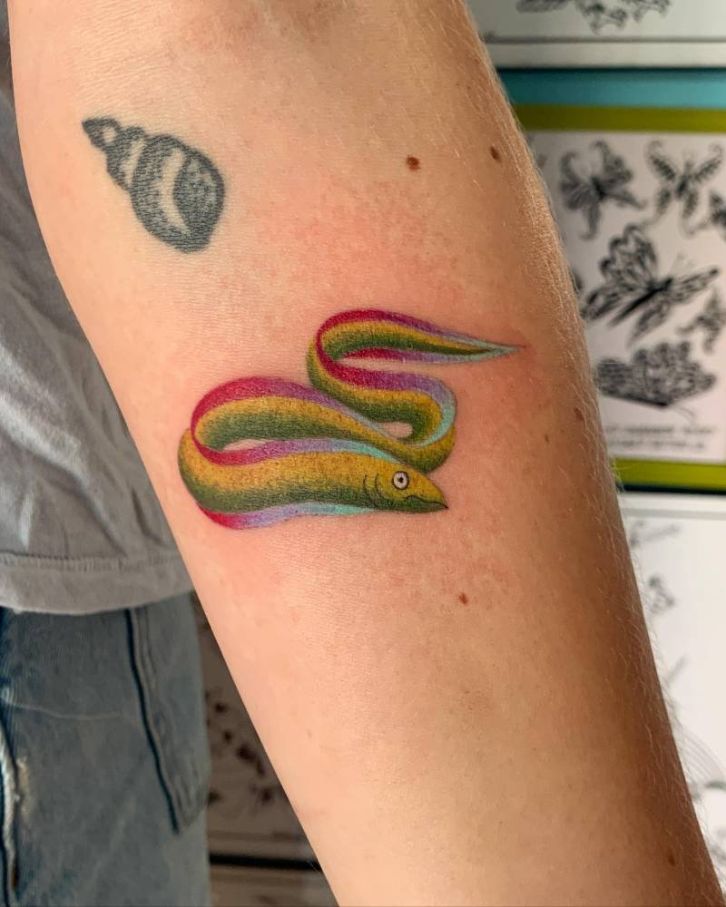 Colorful eel tattoo located on the inner forearm.