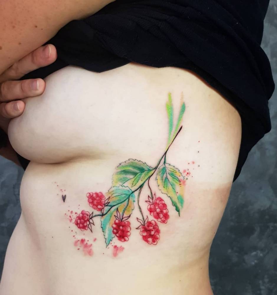 Raspberries tattooed on the rib, watercolor style.