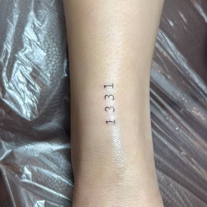 Tattoo of the number "1331" located on the wrist.
