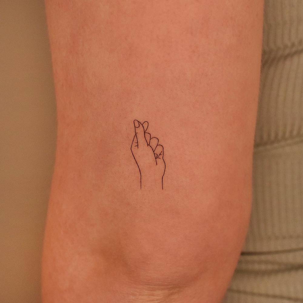 Minimalistic korean finger heart tattoo done on the tricep.