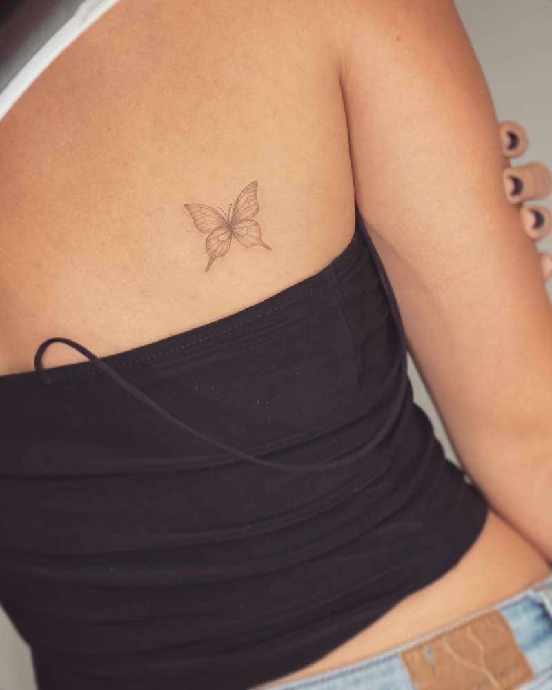 Small butterfly tattoo located on the shoulder blade.
