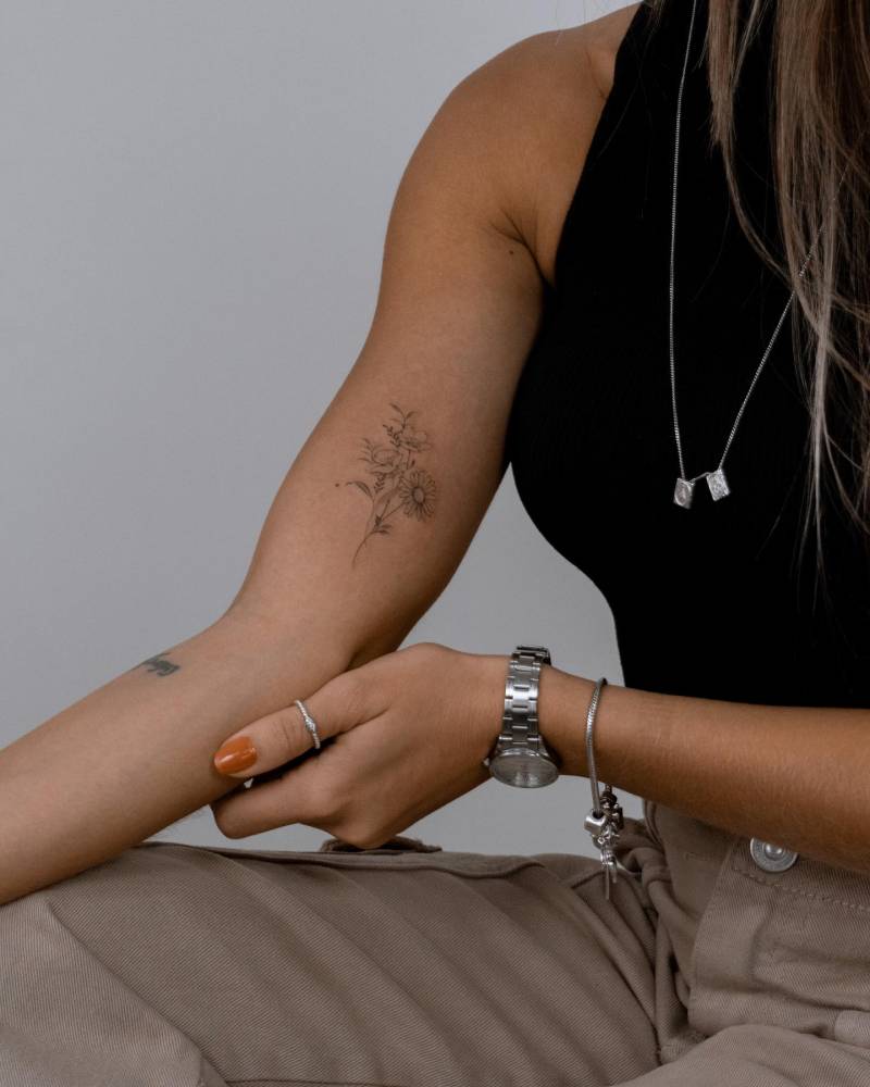 Flower bouquet tattoo done on the inner forearm, illustrative style.