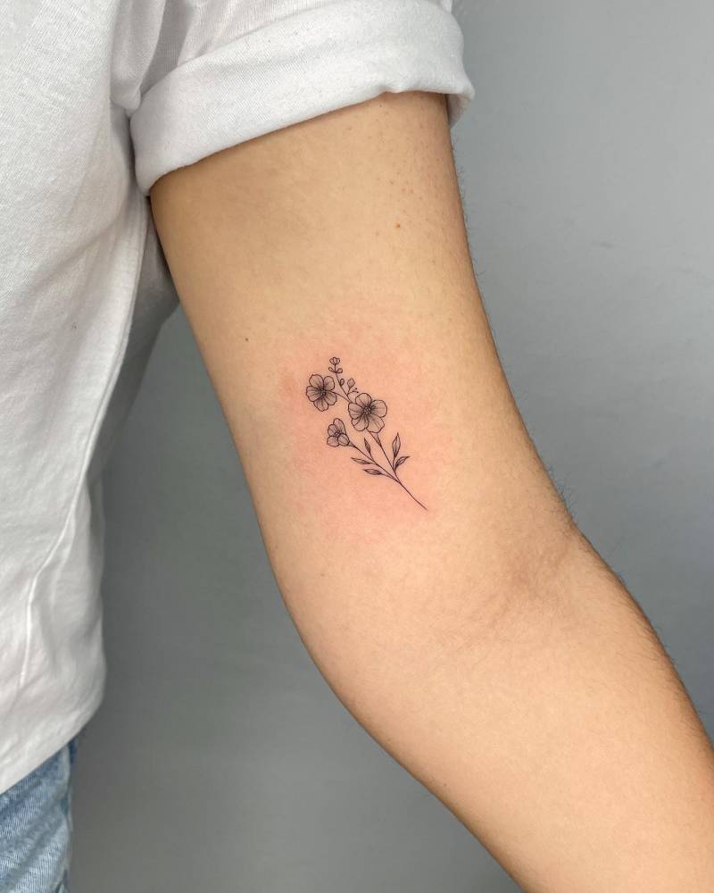 Flowers tattoo located on the inner arm, illustrative style.