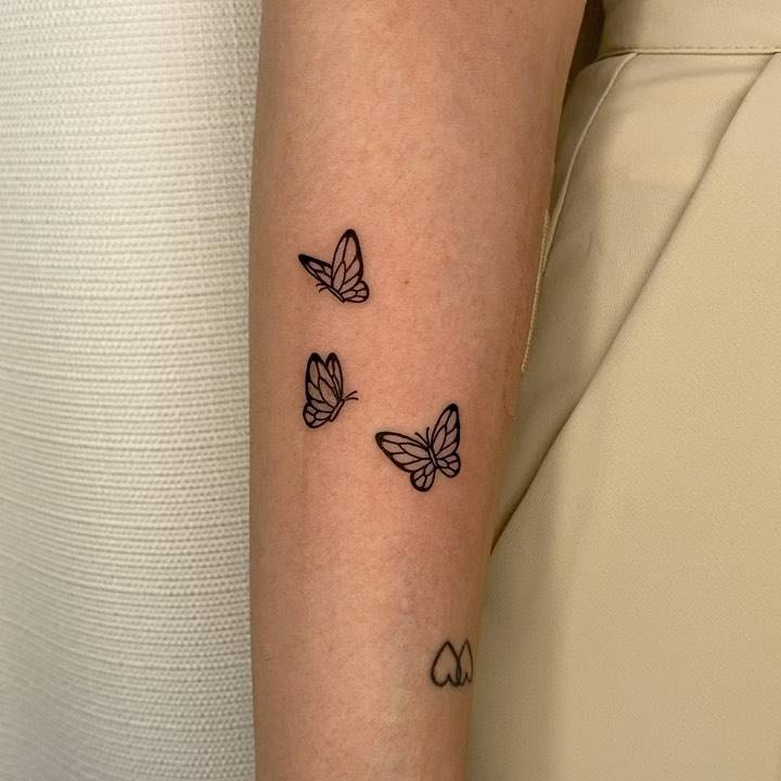 Little butterflies tattooed on the forearm.