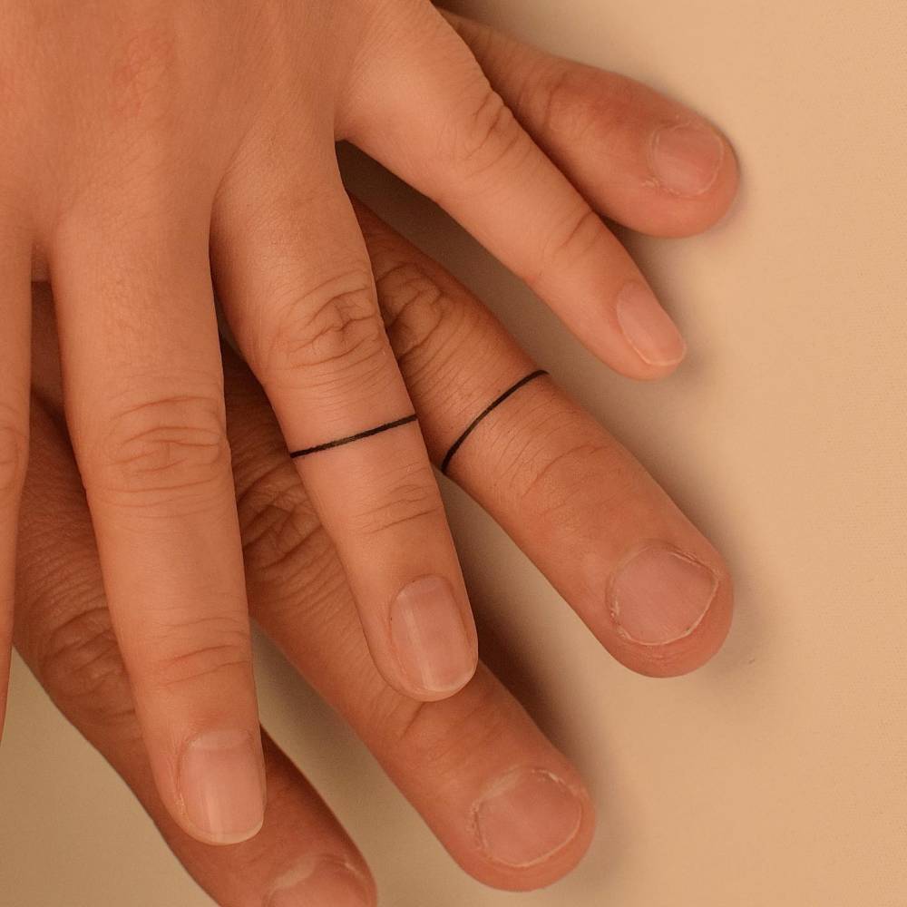 Matching minimalistic ring tattoo for couple.
