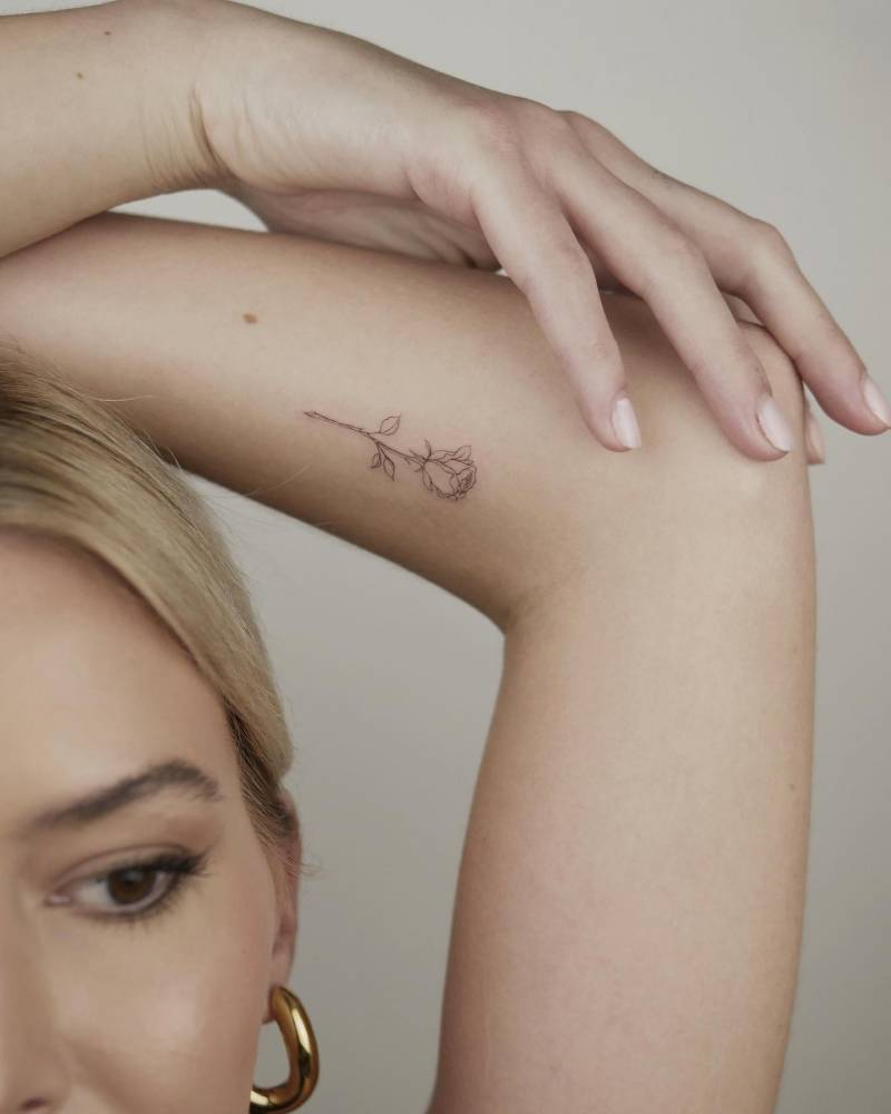 Fine line style rose tattoo located on the inner forearm.