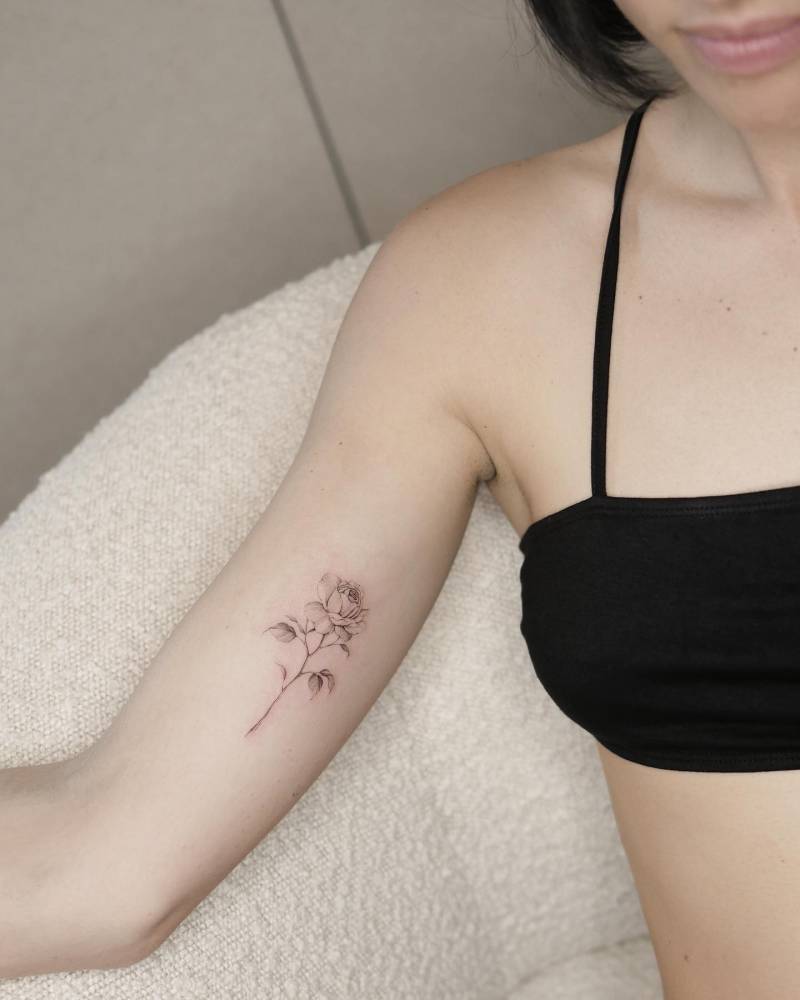 Micro-realistic style rose tattoo located on the inner arm.