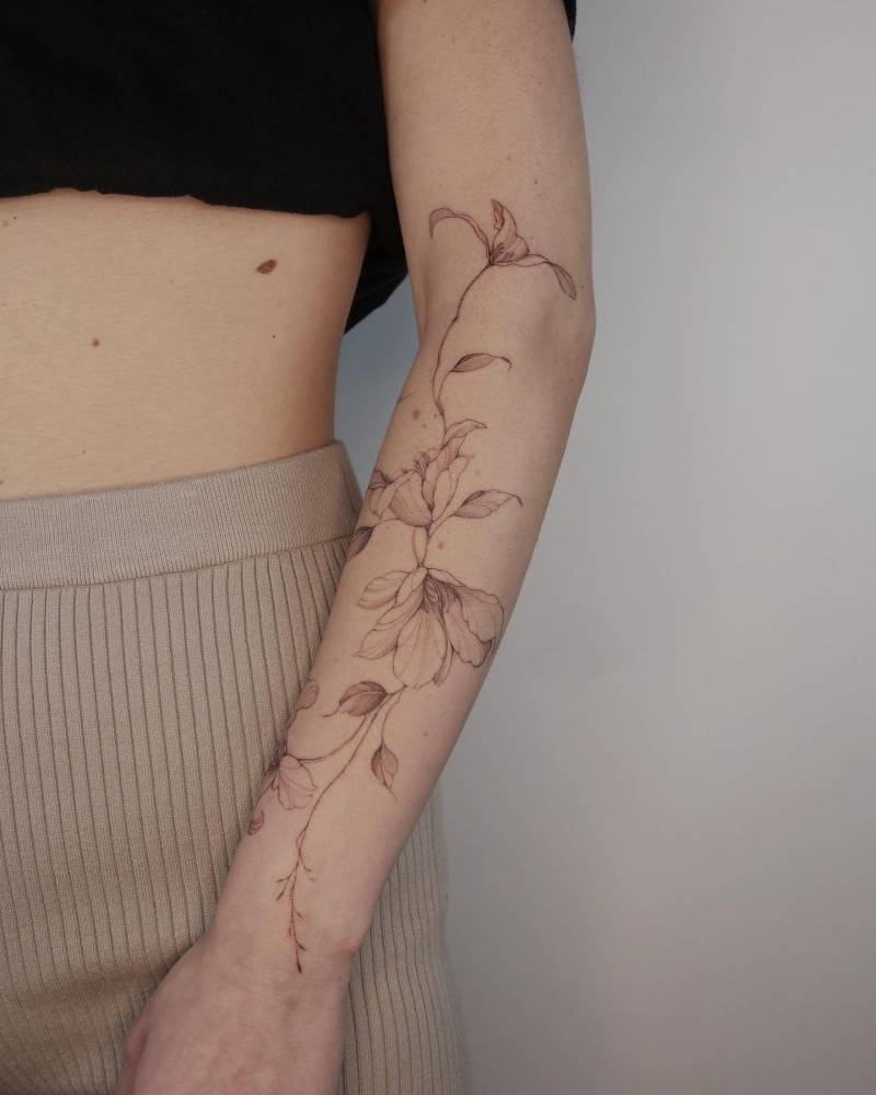 Magnolias tattoo located on the forearm, illustrative style.