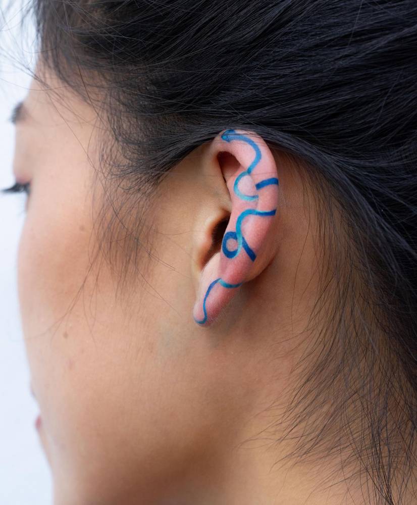 Blue snake tattoo located on the ear.