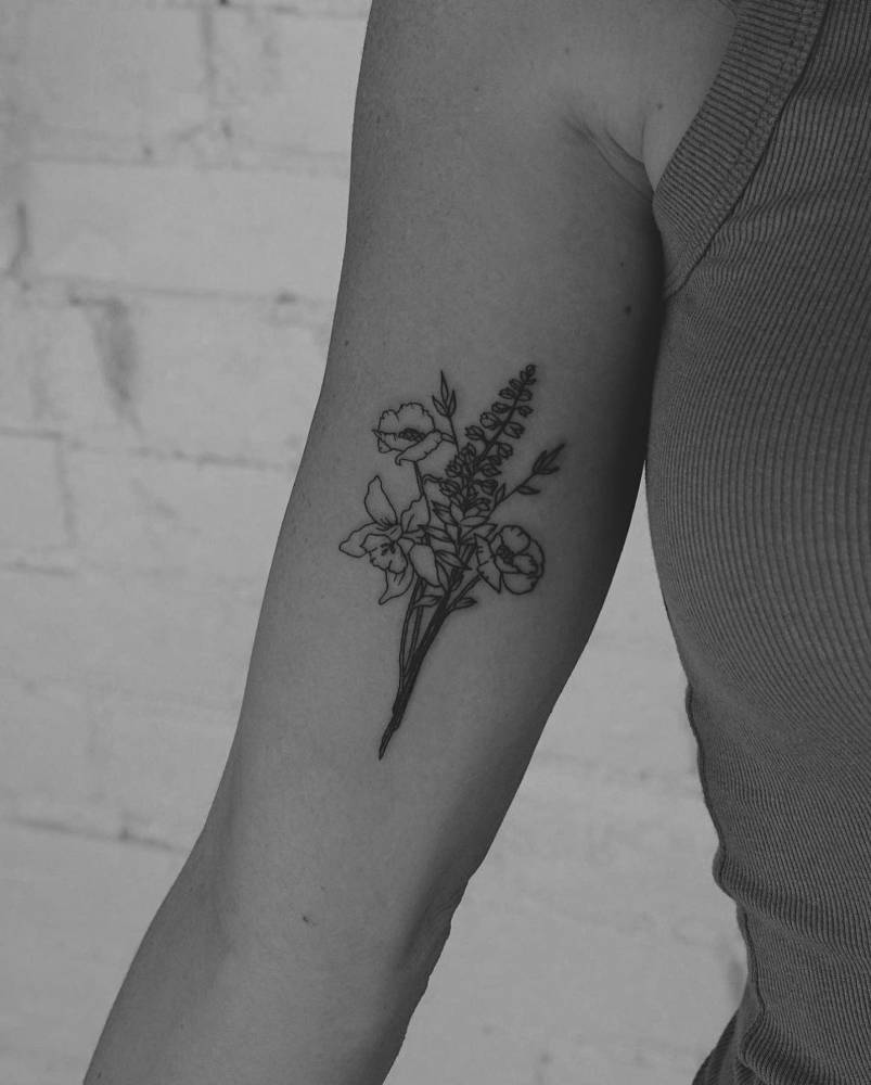 Flower bouquet tattoo placed on the inner arm, done in fine line style.