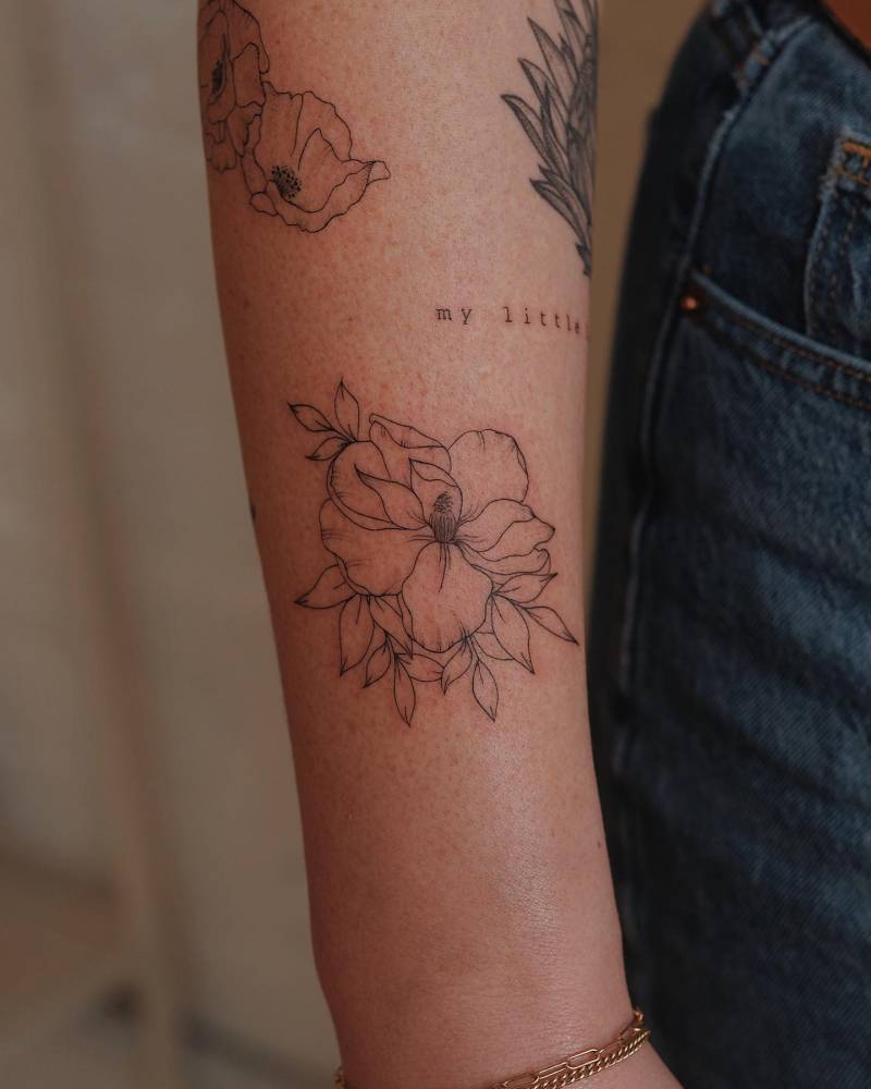 Fine line style flower tattoo located on the forearm