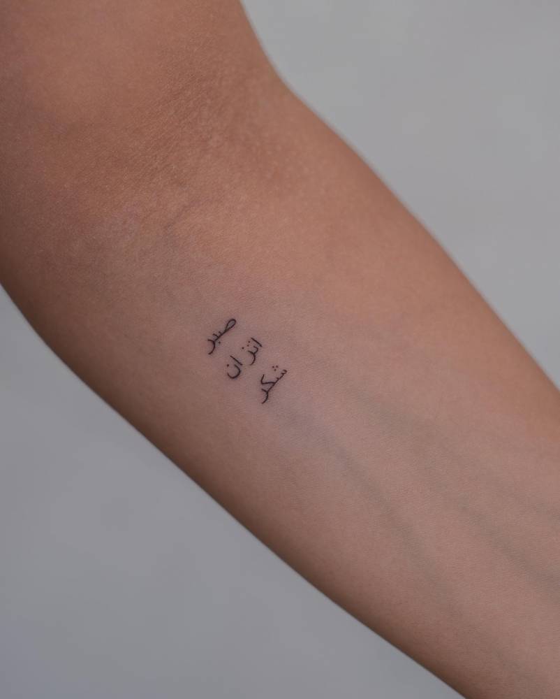 Arabic lettering tattoo located on the inner forearm.
