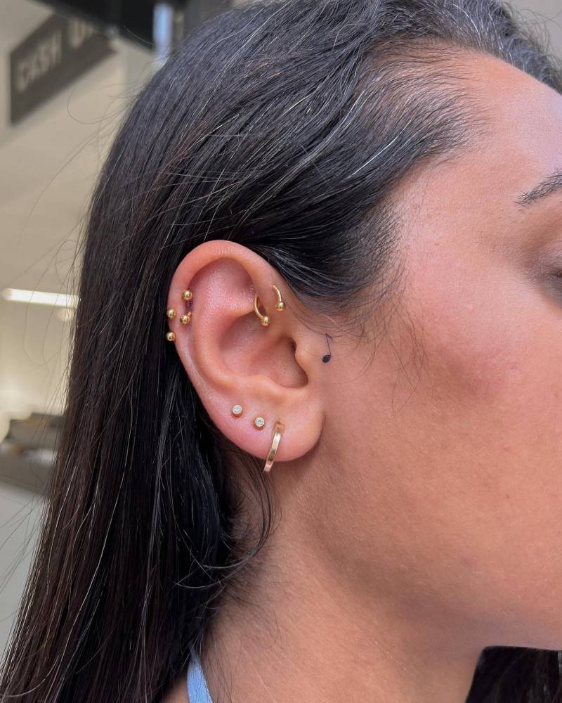 Minimalistic quaver tattoo located on the ear.