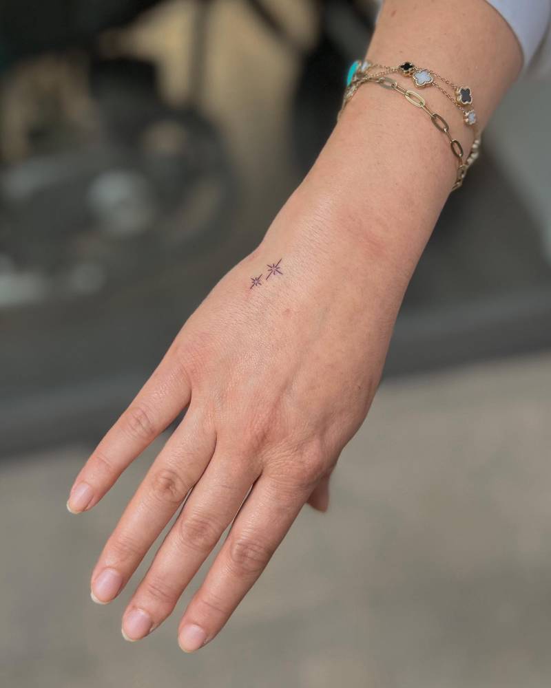 Cute tiny stars tattoo located on the hand.