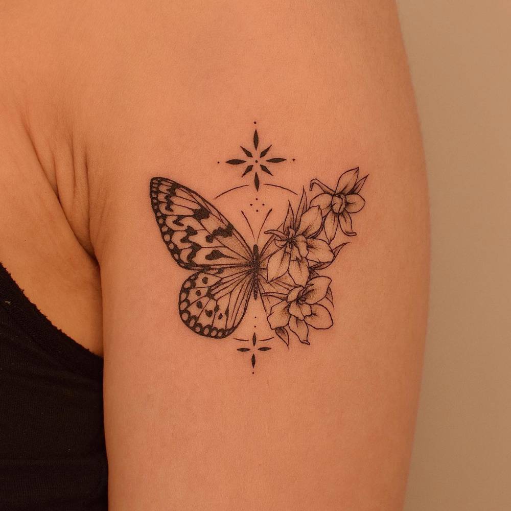 Illustrative style half butterfly half flower tattoo done on the upper arm.