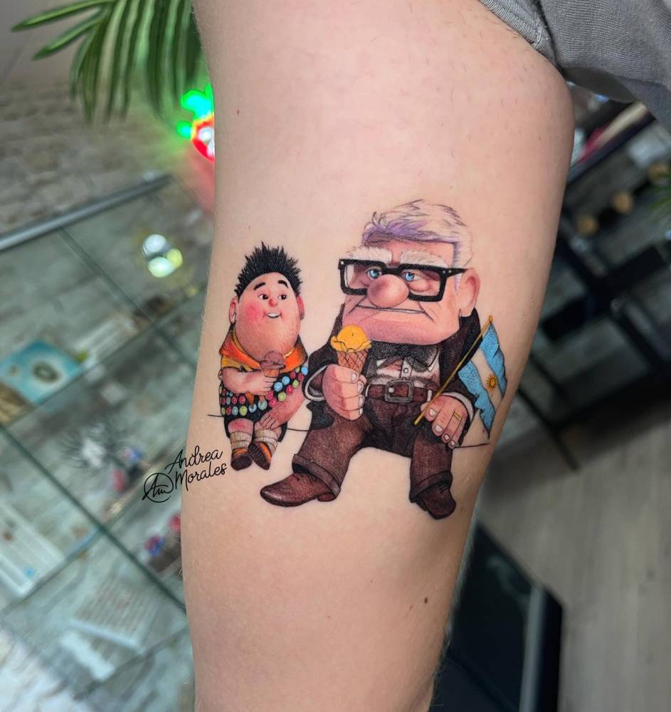 'Up' tattoo in cartoon style located on the inner arm.