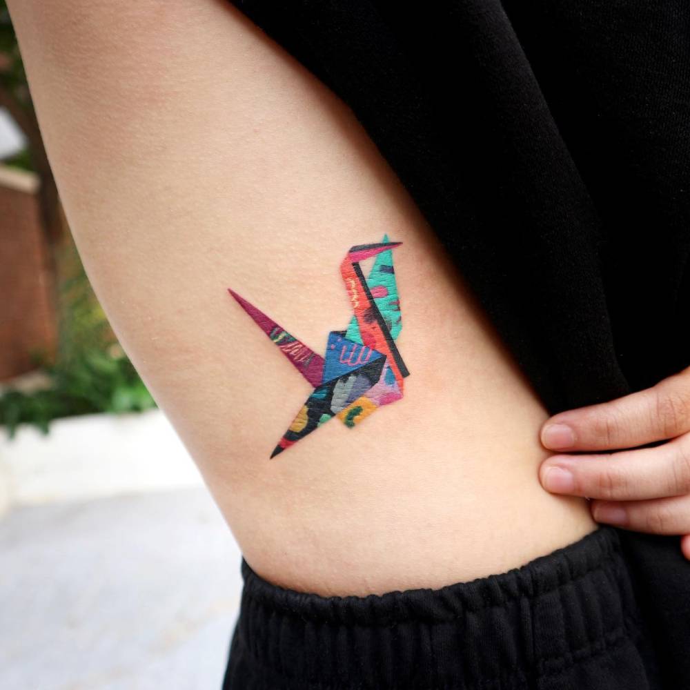 Pop art style origami crane tattoo done on the rib.