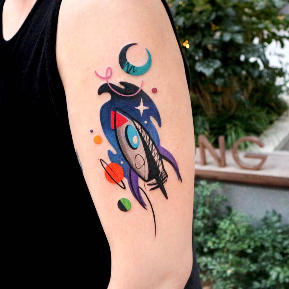Pop art style rocket tattoo located on the upper arm.