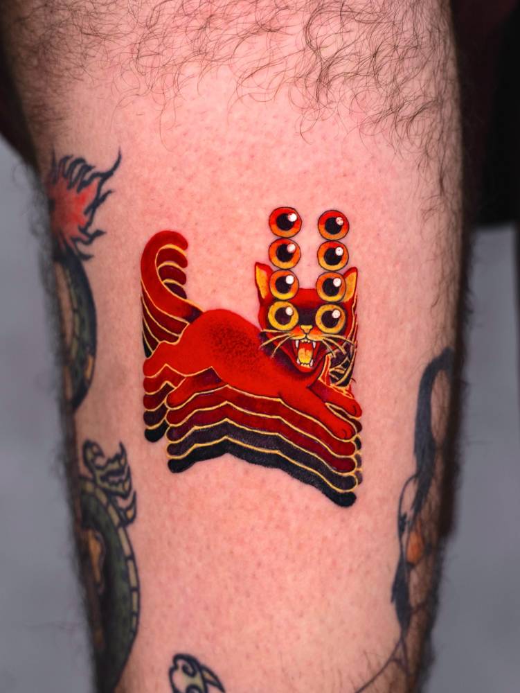 Trippy cat tattoo located on the thigh, pop art style.