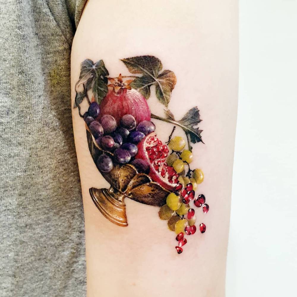 Fruit bowl tattoo in micro-realism located on the tricep.