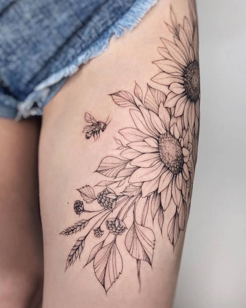 Large sunflowers tattoo located on the thigh.
