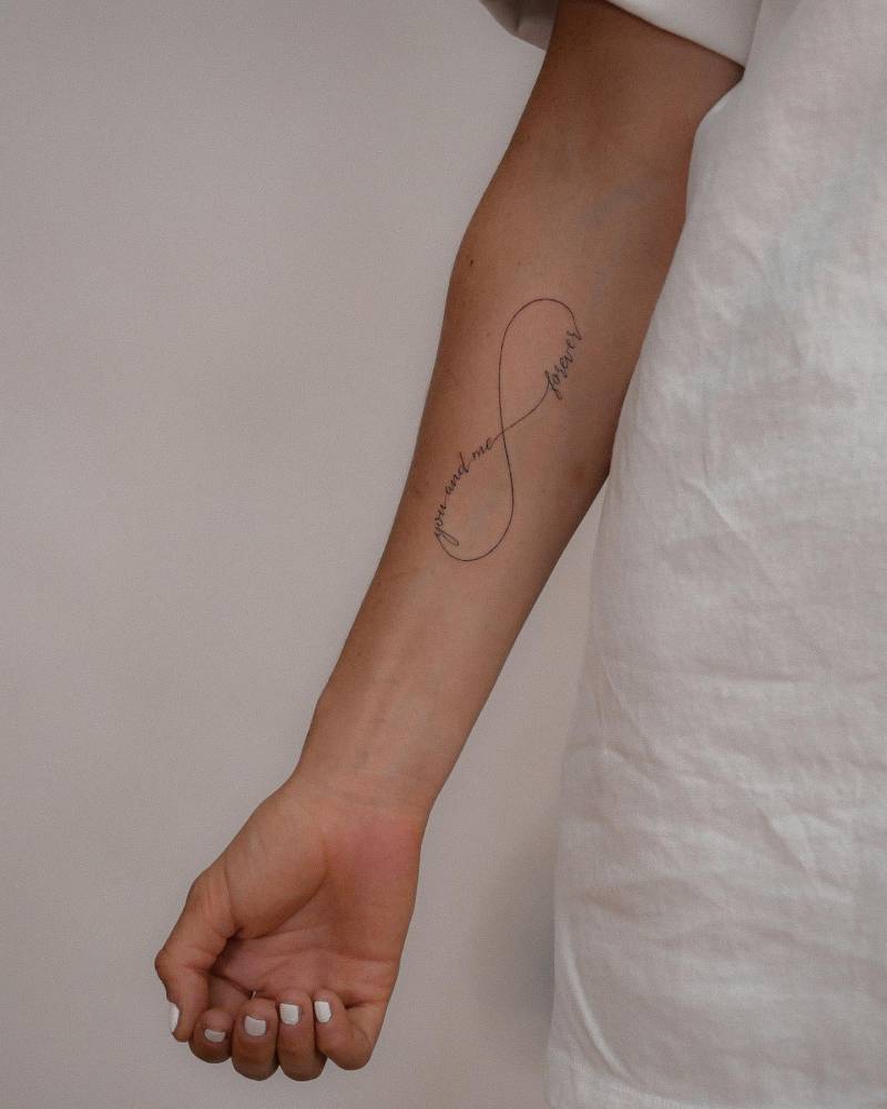 "You and me forever" and infinity symbol tattooed on the inner forearm.