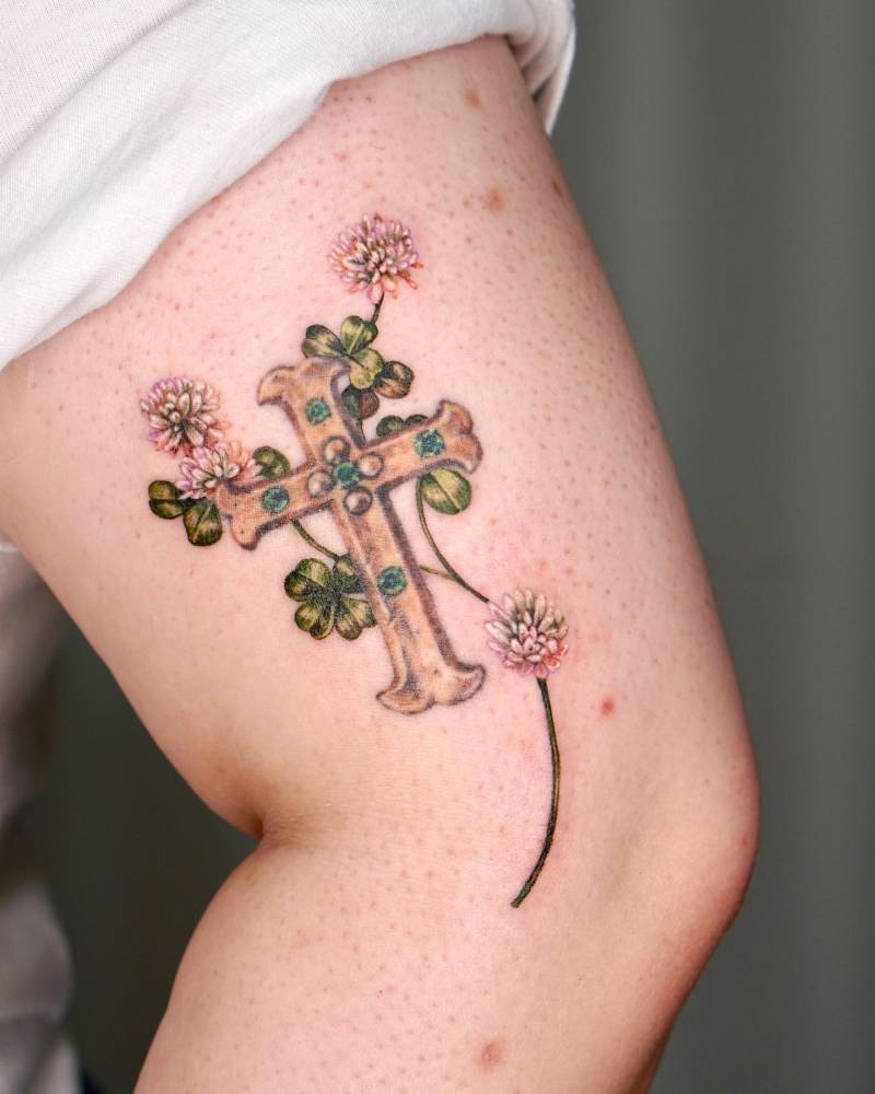 Flower cross tattoo located on the upper arm.