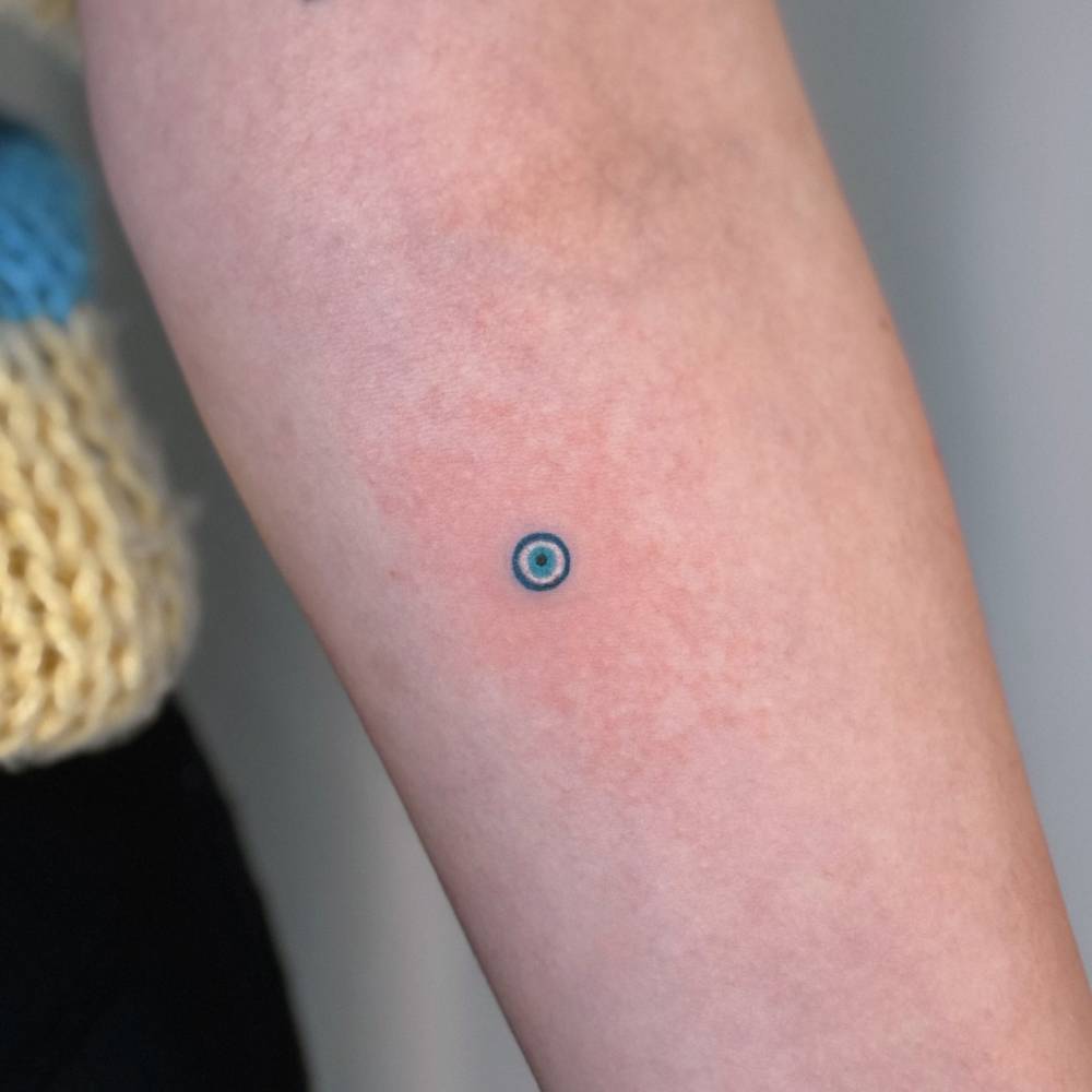 Tiny Nazar eye tattoo placed on the inner forearm.
