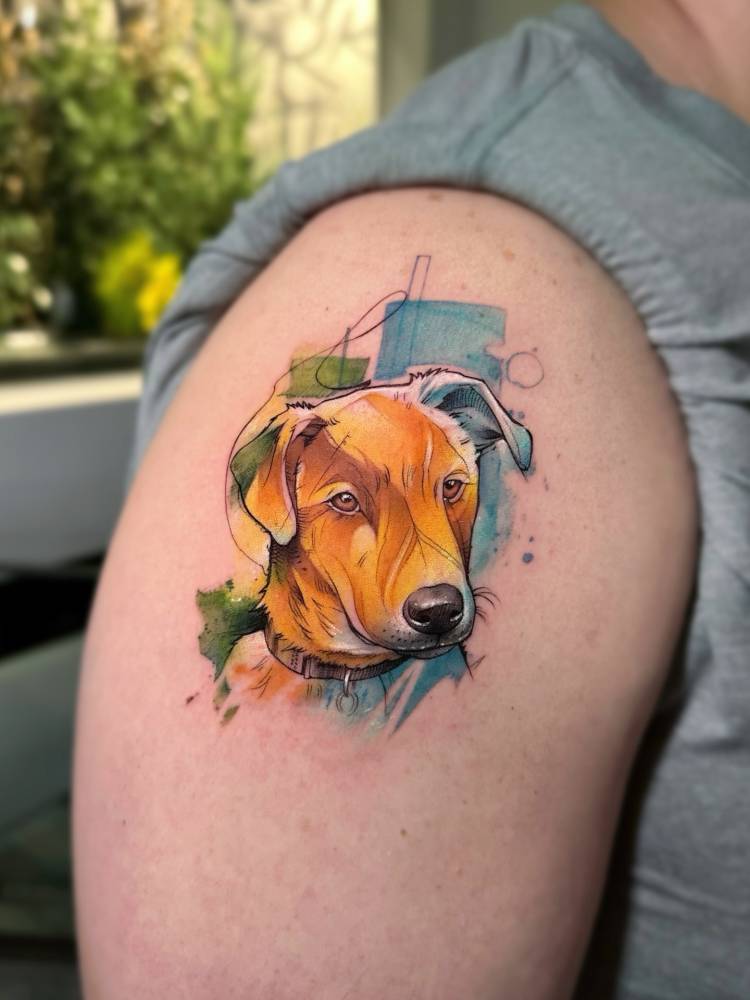 Watercolor style dog portrait tattoo done on the shoulder.