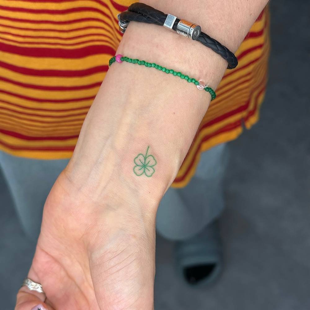 Hand poked four leaf clover tattoo located on the wrist.