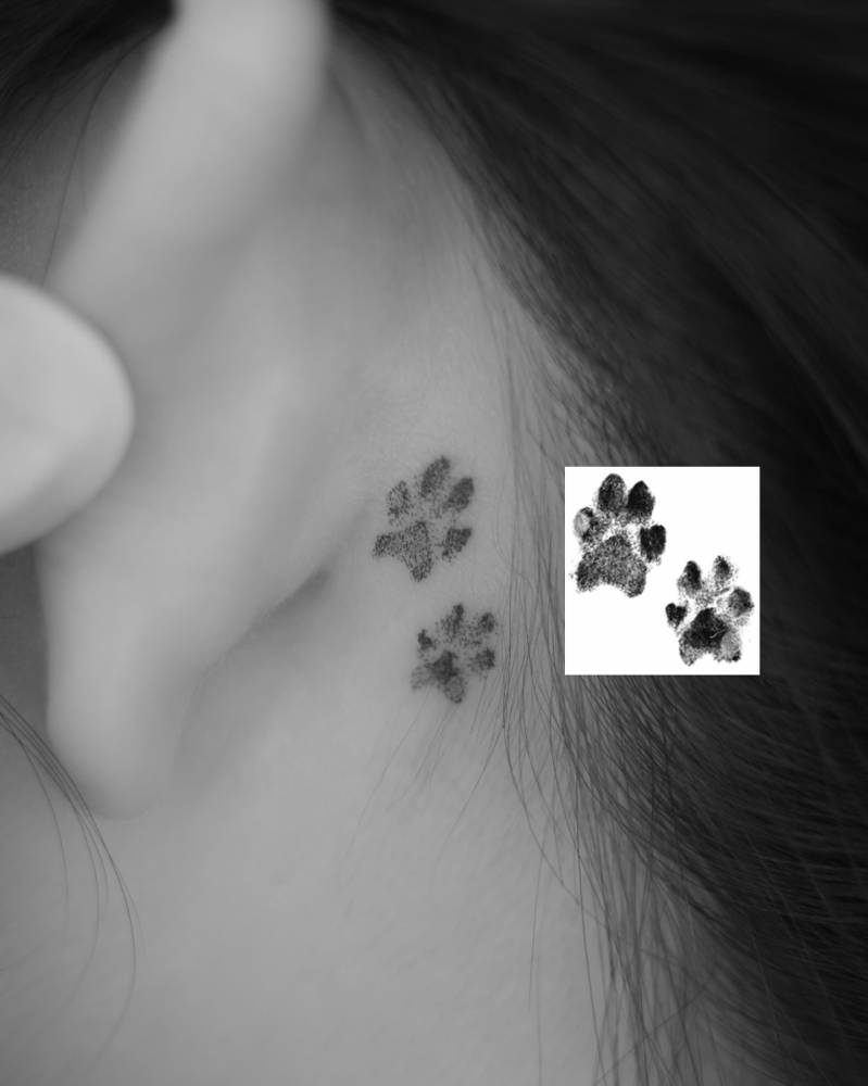 Little paw prints tattoo located behind the ear.