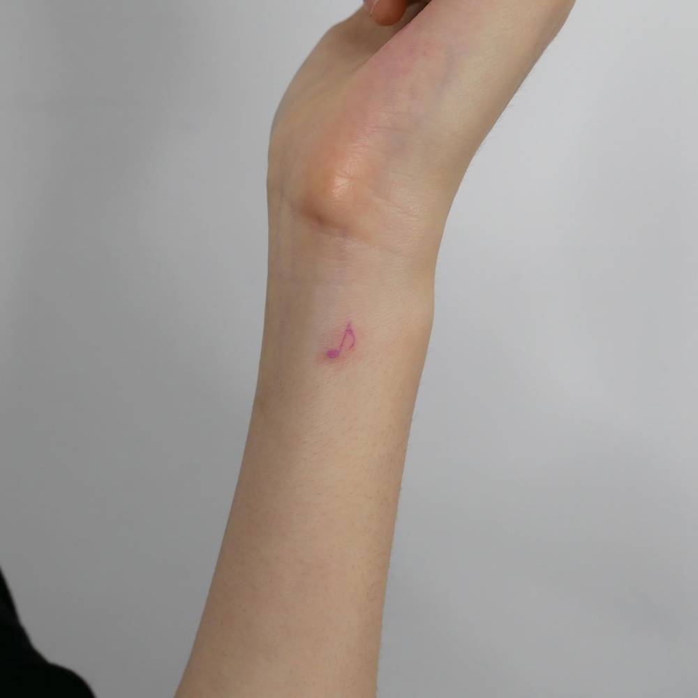 Quaver tattoo located on the wrist, minimalistic style.