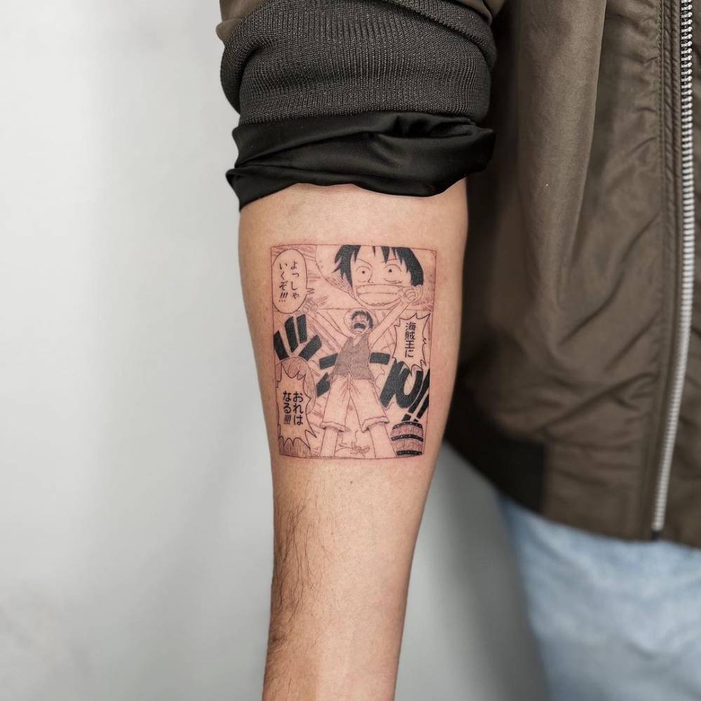 One Piece's Luffy tattooed on the inner forearm, cartoon style.