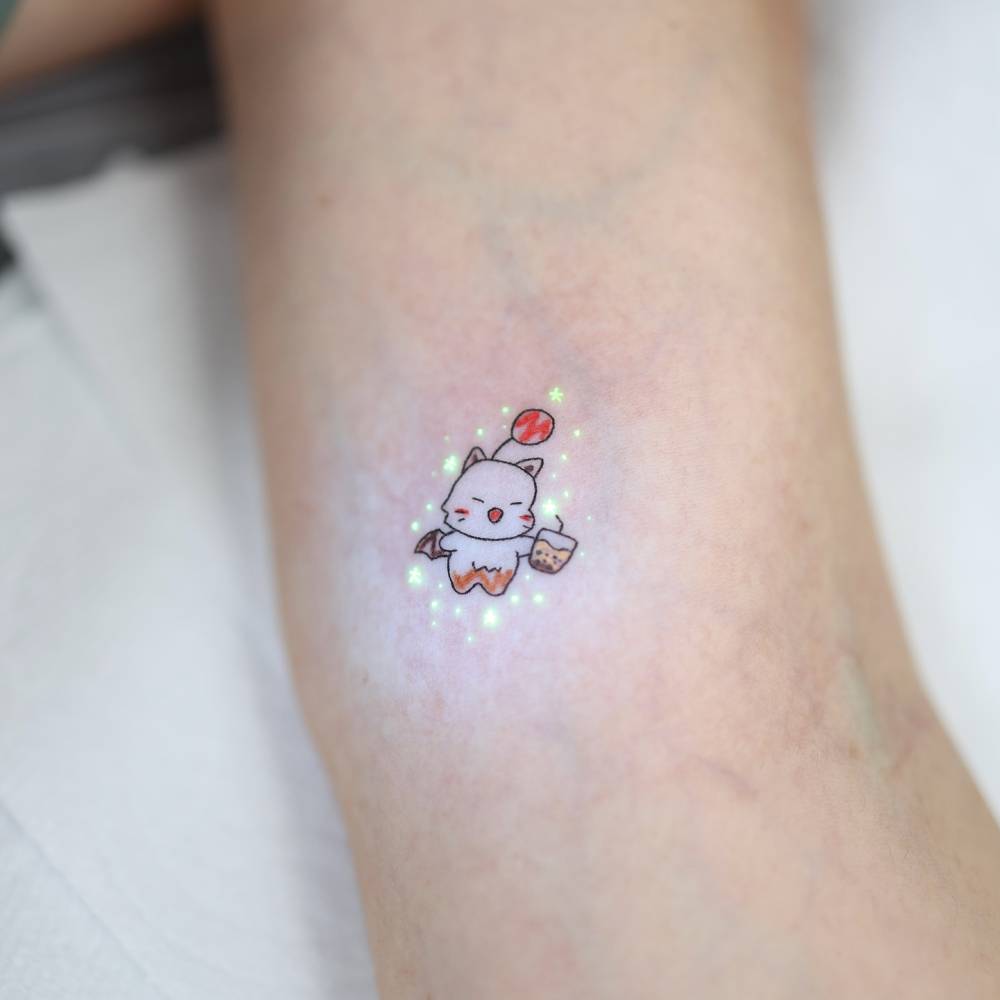 Moogle tattoo located on the inner arm, done in cartoon style.