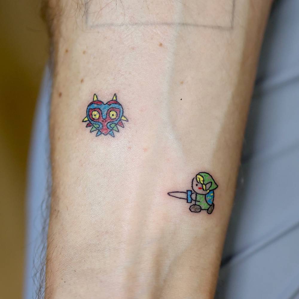 Majora's Mask and Link tattooed on the wrist, done in cartoon style.