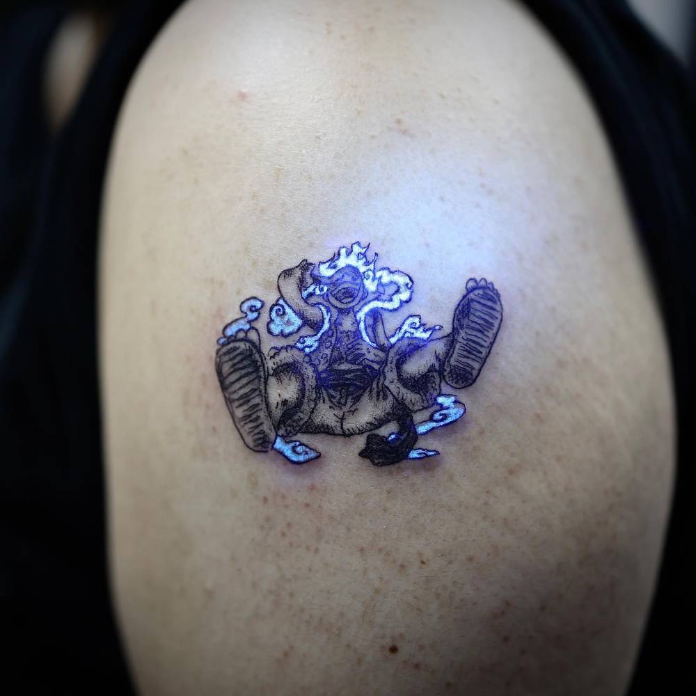 UV ink Luffy tattoo located on the upper arm.