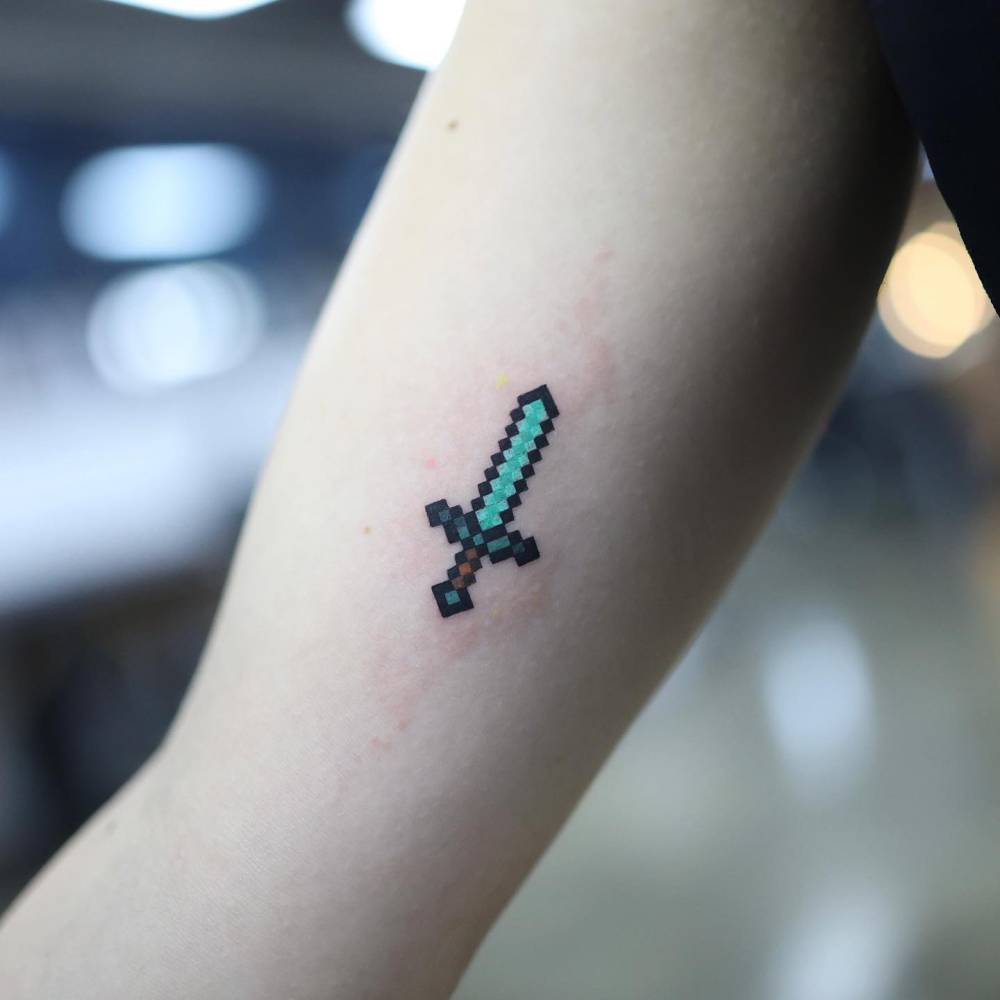 Minecraft sword tattoo located on the inner arm.