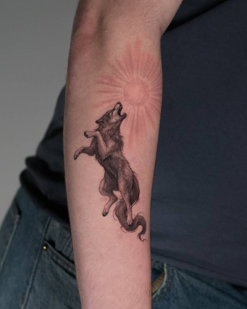 Micro-realistic style wolf and sun tattoo located on the forearm.
