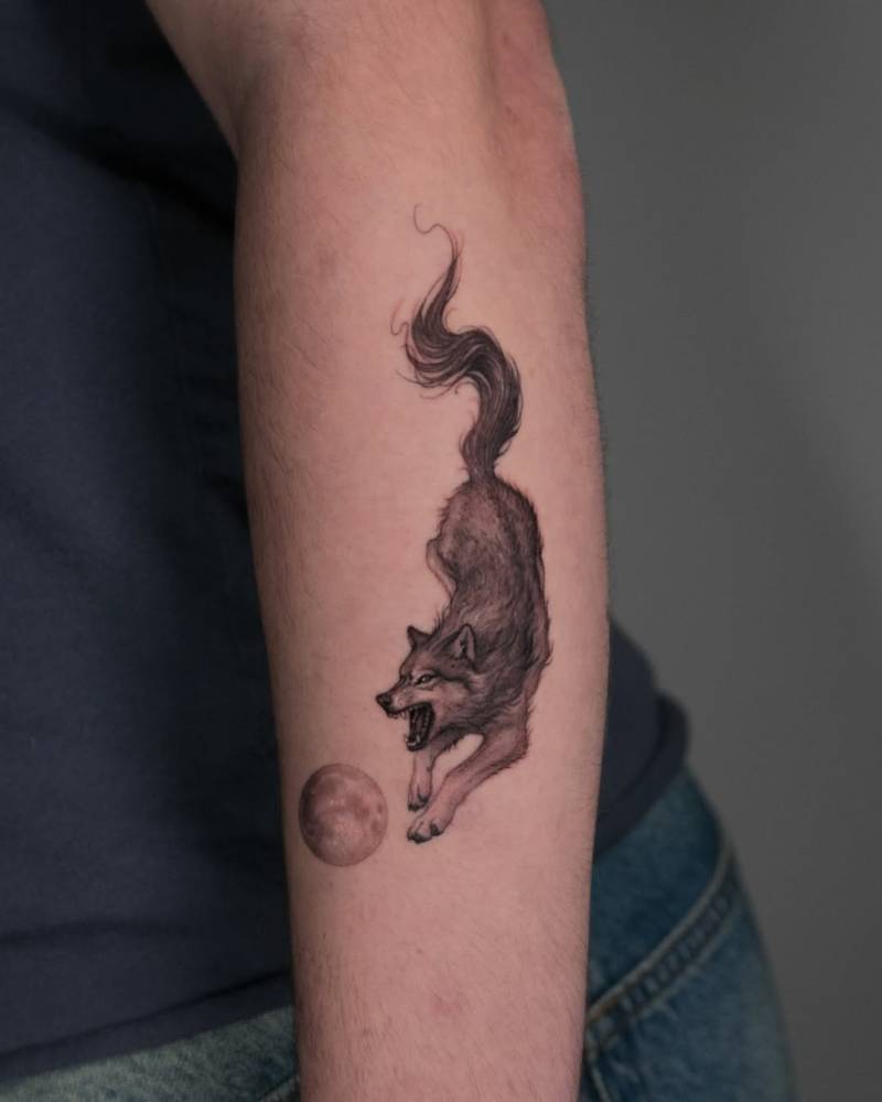 Micro-realistic style wolf and moon tattoo located on the forearm.