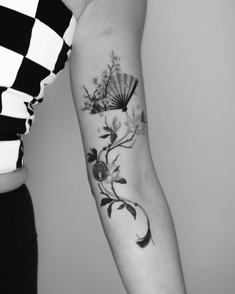Japanese hand fan tattoo located on the arm, micro-realistic style.