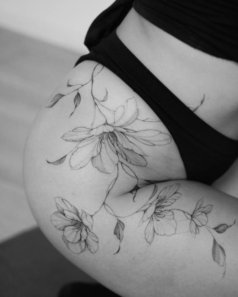 Magnolias tattoo located on the hip, illustrative style.