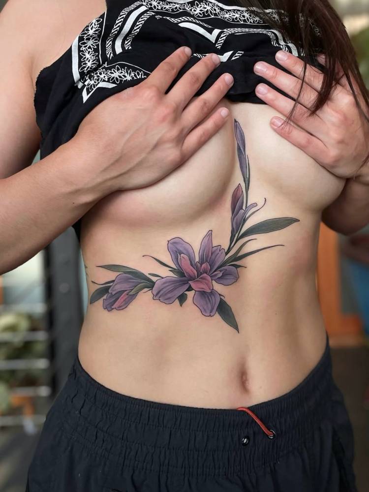Magnolias tattoo in illustrative style located on the rib.