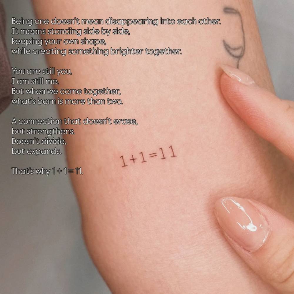 Tiny equation tattoo in typewriter font located on the inner arm.
