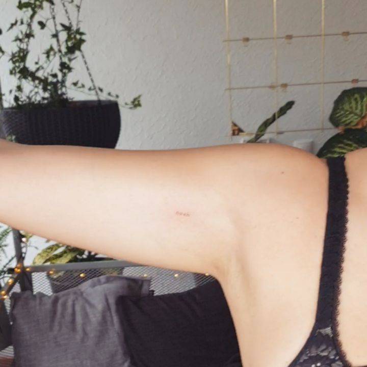 "Noah" lettering tattoo on the inner arm.