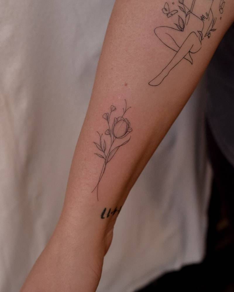 Tulip tattoo in fine line style placed on the wrist.