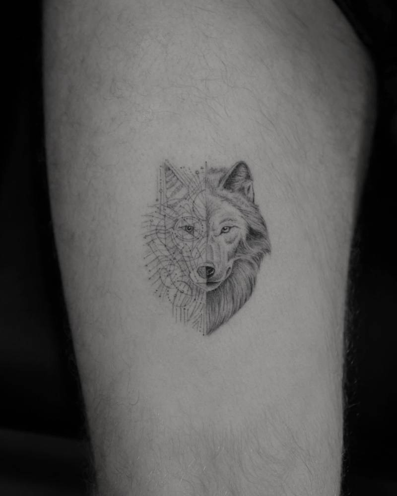 Micro-realistic style wolf portrait tattoo located on the thigh.