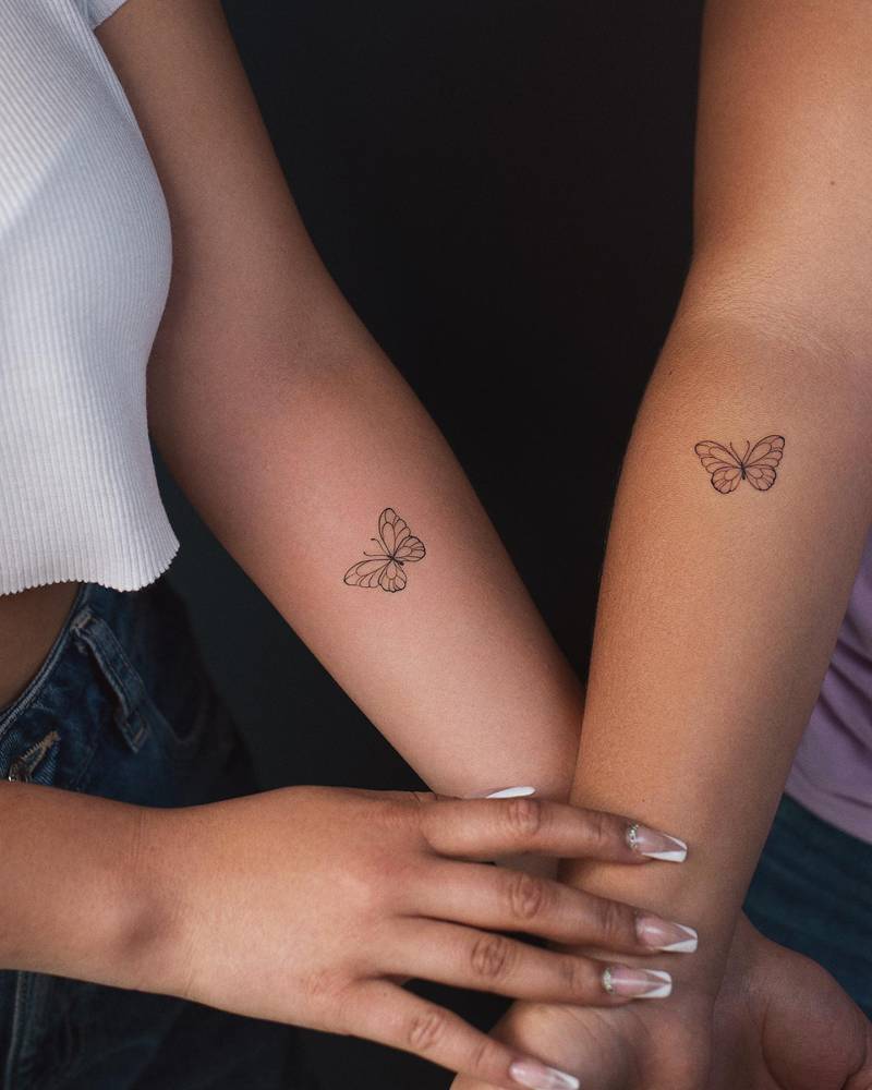 Matching fine line style butterflies tattoo placed on the inner forearm.
