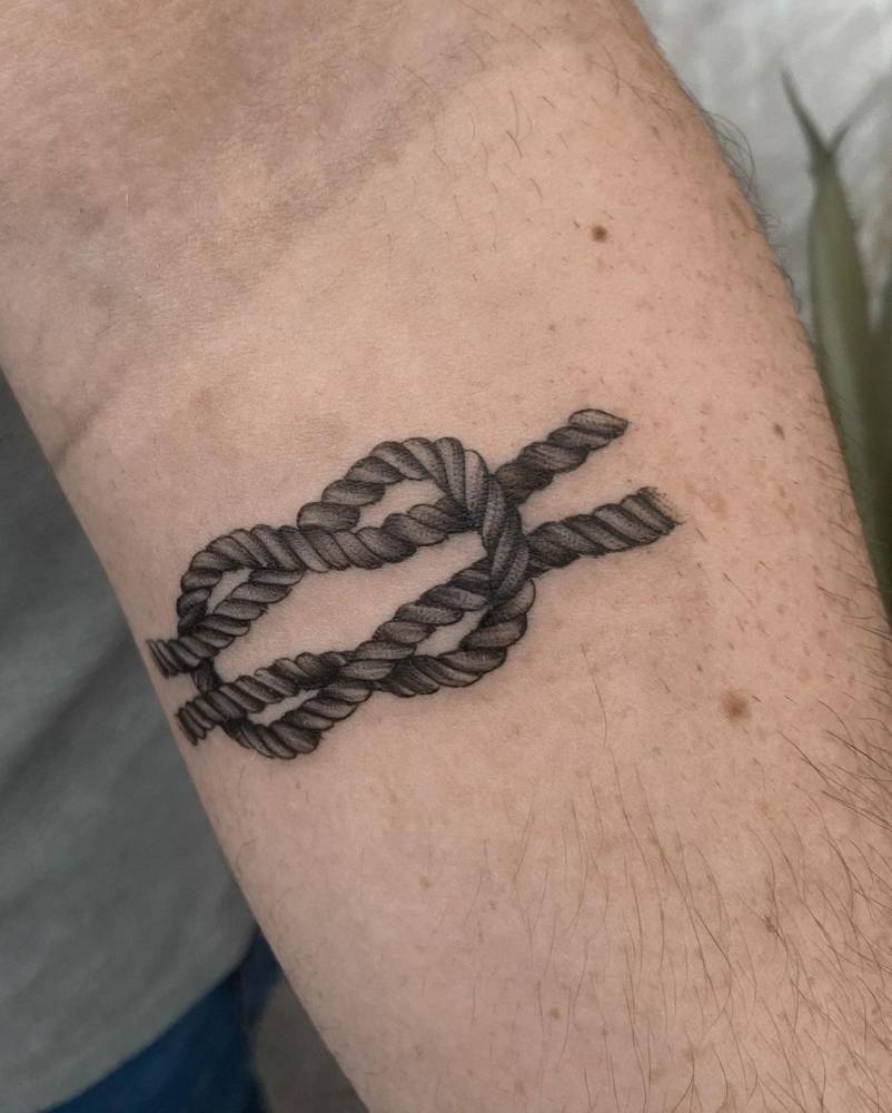 Micro-realistic knot tattoo on the inner forearm.